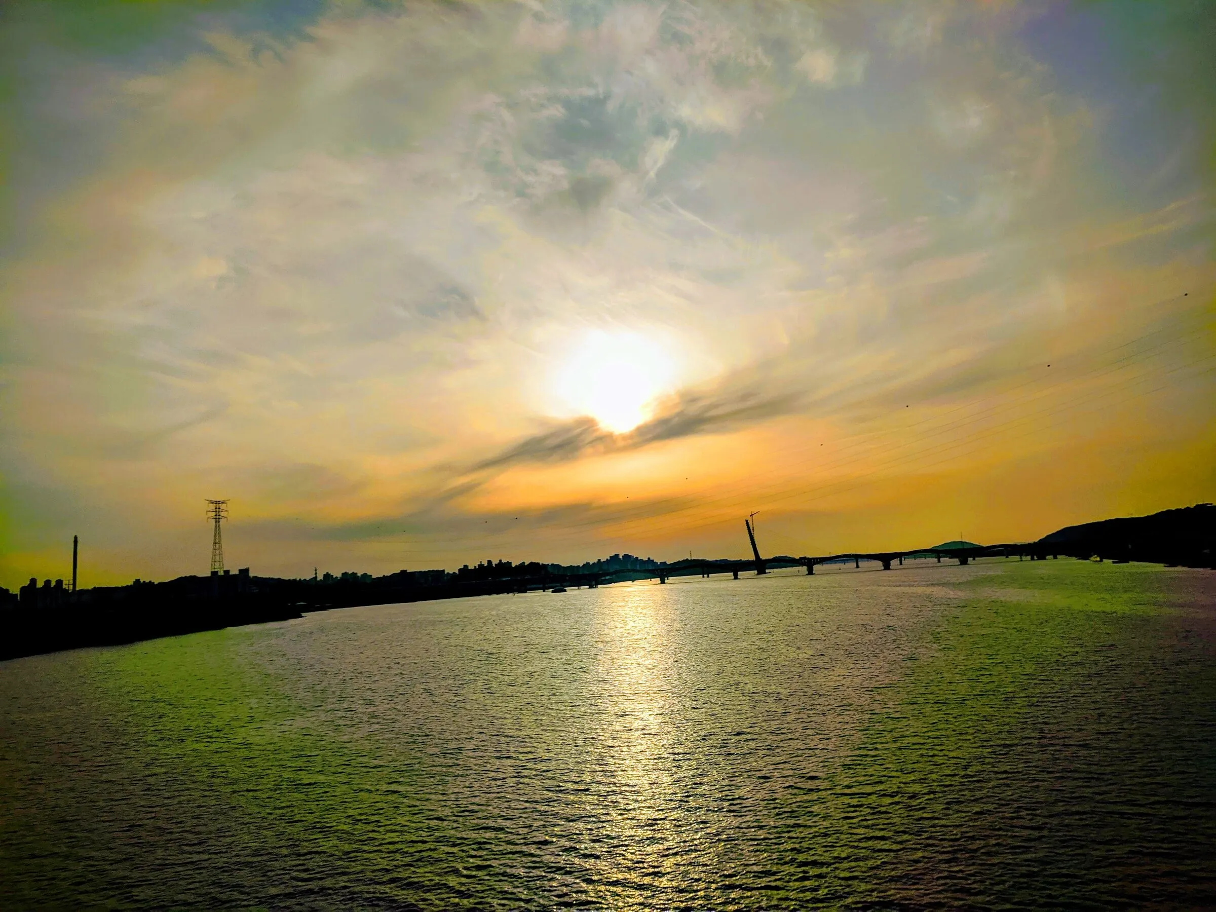 A golden summer sunset over the Han River, viewed from the Mapo riverbank.
