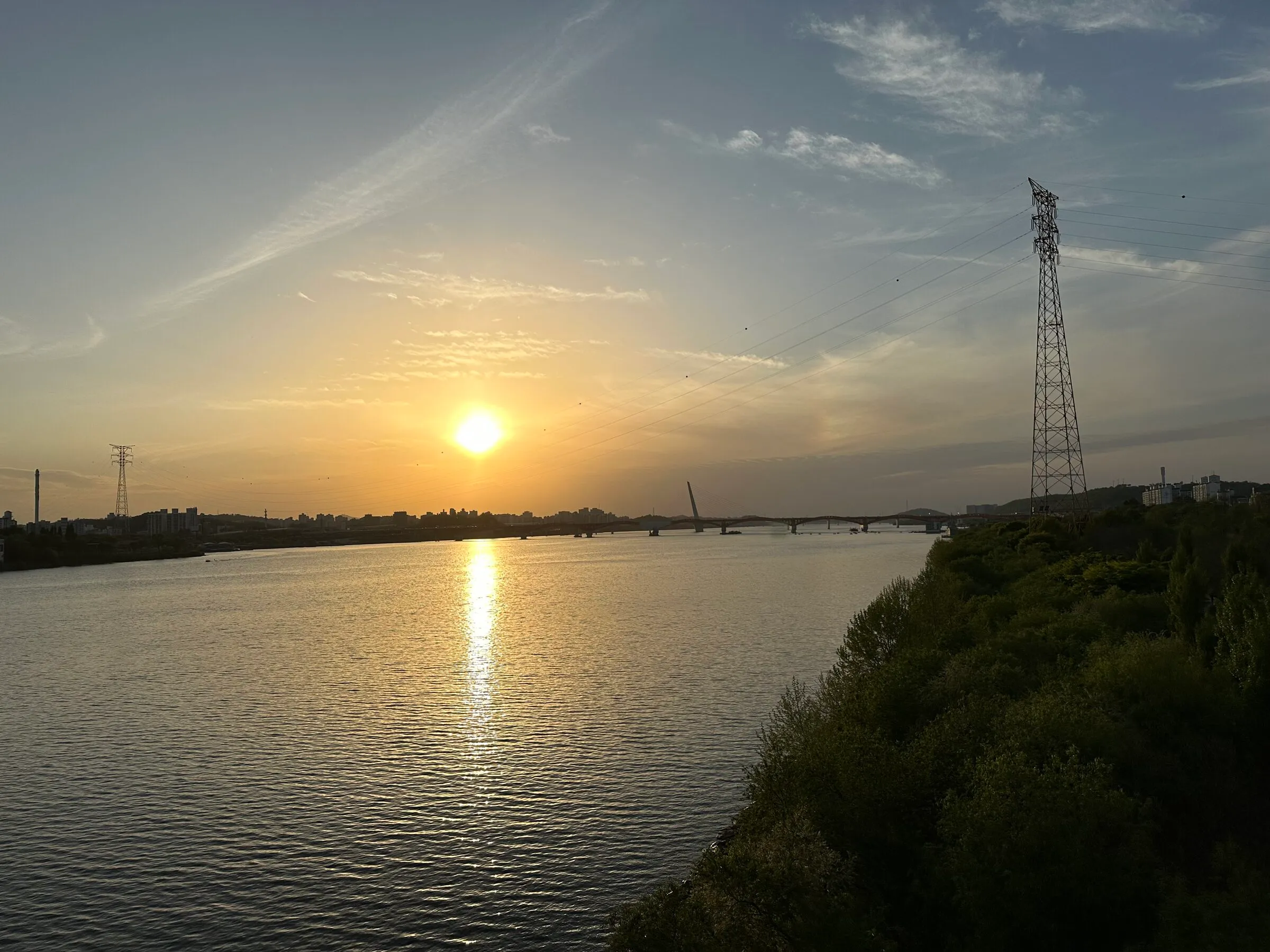 A golden spring sunset reflected across the calm Han River in Mapo.
