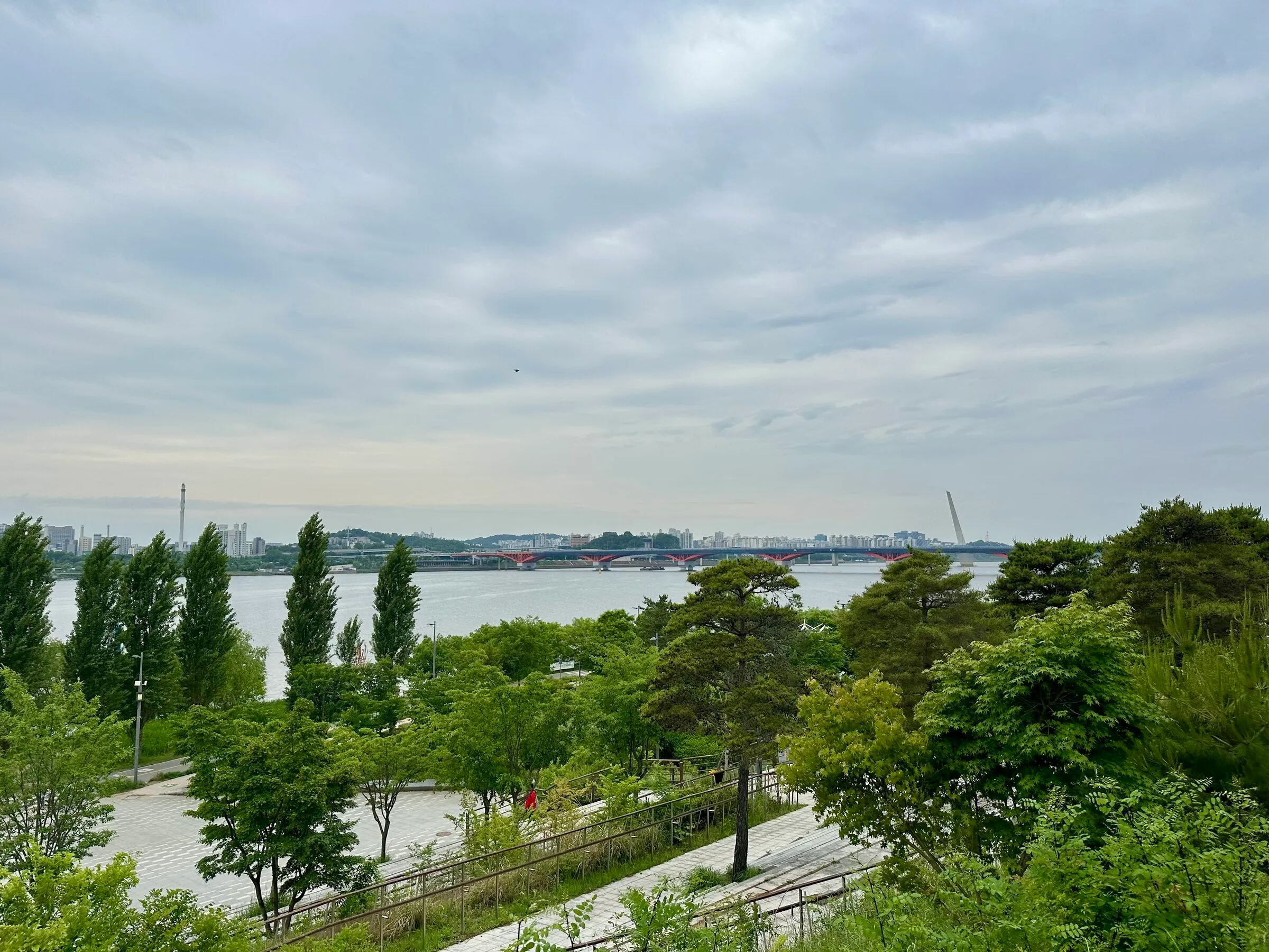 The view west from the route start at Hapjeong: Han River, distant bridges, lush greenery on a cloudy spring day.