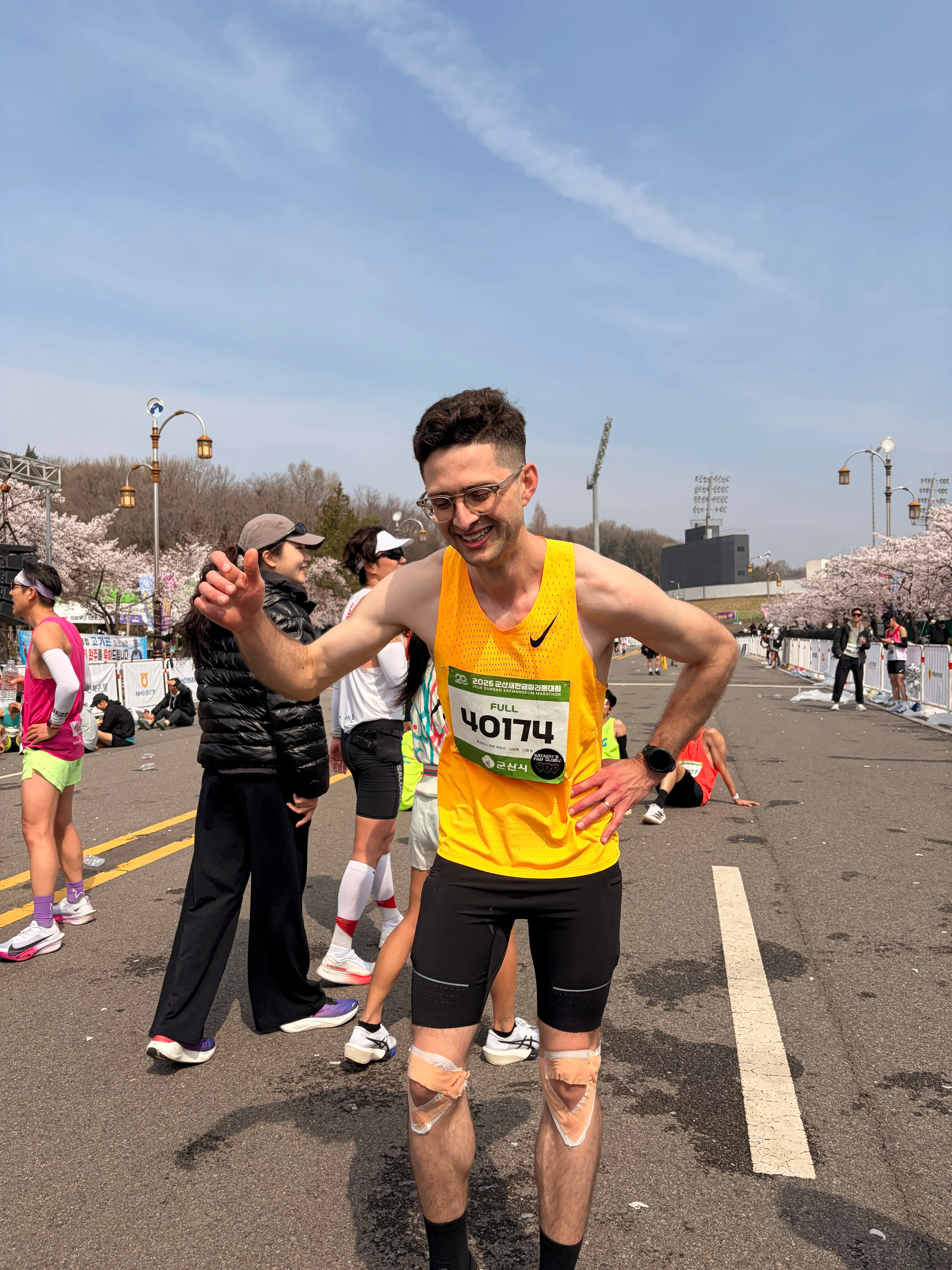Quintin running past cherry blossoms at the 2026 Gunsan Saemangeum Marathon.