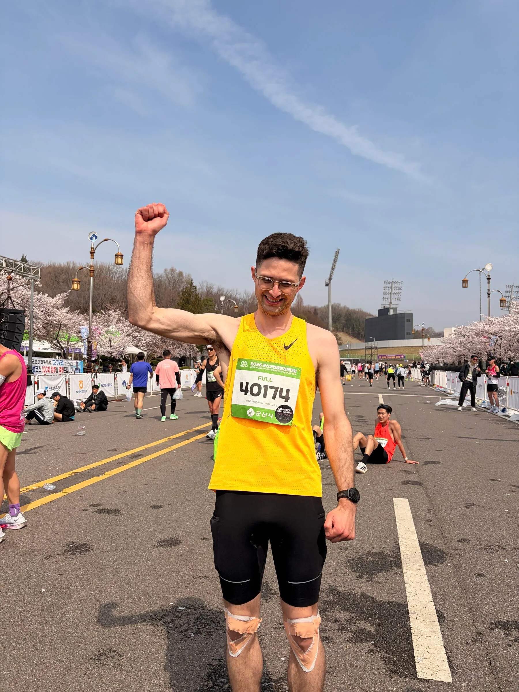 Quintin racing a road marathon in Korea, fist raised.