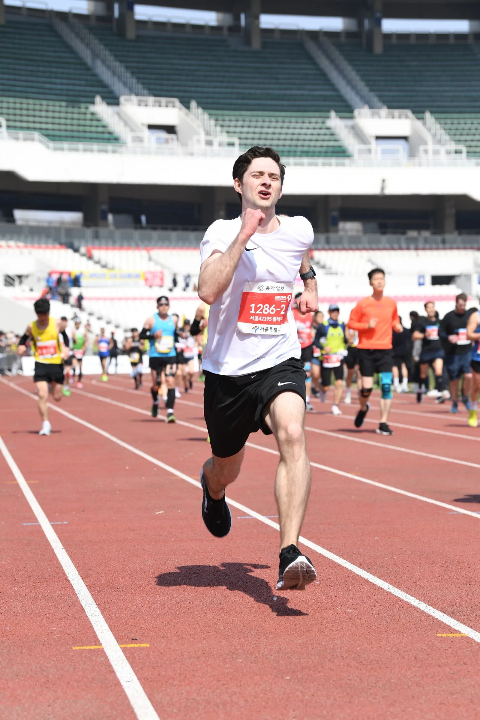 Quintin sprinting on the Olympic Stadium track at the Seoul Marathon 2023 finish.