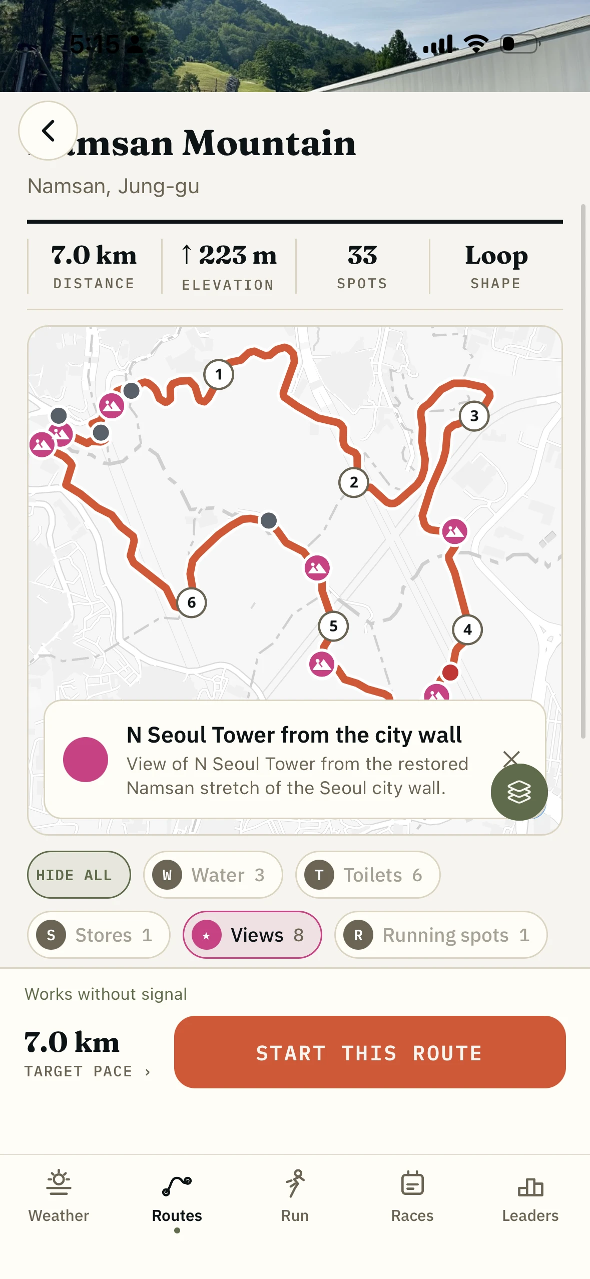 A route map with a tapped spot opening its written note, on the cherry-blossom road behind the National Assembly